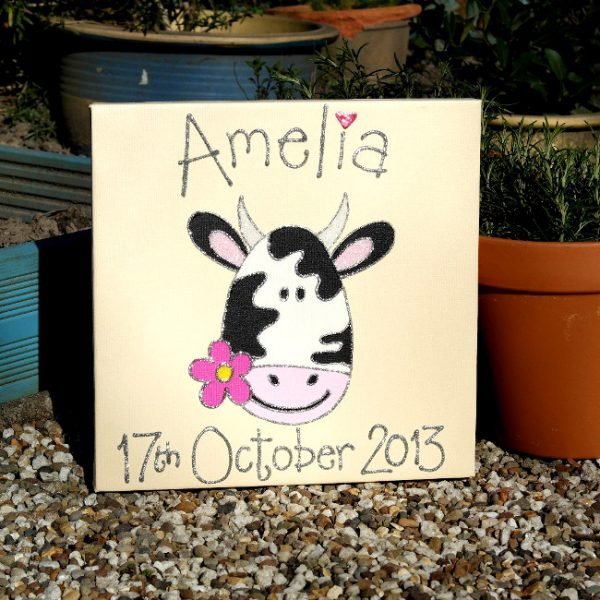 A personalised canvas picture of an adorable black and white cow holding a pink flower in its mouth.