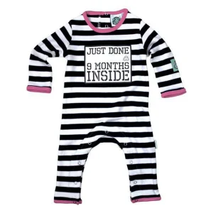 A fun baby grow in black and white stripes with a bright pink trim around the arms, legs and neck line. The suit looks like a prison uniform!The slogan on the front says just done 9 months inside
