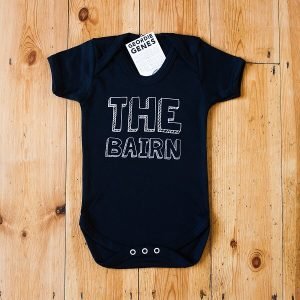 Black geordie baby vest with The Bairn on the front in a block font. The baby vest is available in white too and in sizes birth to 18 months