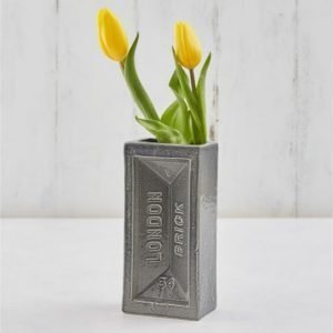 A grey ceramic vase shaped like a house brick, stamped with London Brick
