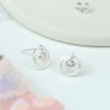 A pair of sterling silver circle crystal heart earrings. Stud earrings with a scratched textured circle enclosing a crystal heart