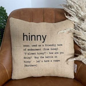 A North East inspired cushion made from hessian and backed with striped ticking. The cushion has a colloquial dictionary quote of what Hinny means.