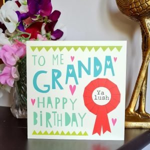 A geordie Granda card with To me Granda happy birthday and a red rosette with ya lush printed in the middle