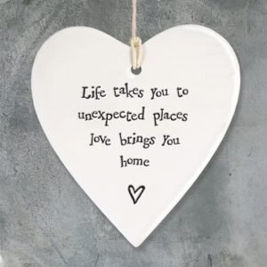 a cream porcelain hanging heart with the words Life take you to unexpected places love brings you home. a lovely little gift