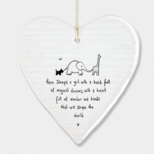 A wobbly cream porcelain heart decorated with a dog, elephant and giraffe and the words Here sleeps a girl with a head full of magical dreams, with a heart full of wonder and hands that will shape the world. A lovely gift for a newborn baby girl