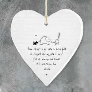 A wobbly cream porcelain heart with the words Here sleeps a girl with a head full of magical dreams, with a heart full of wonder and hands that will shape the world. A lovely gift for a newborn baby girl