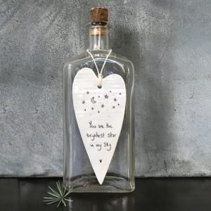 A cream porcelain hanging heart decoration stamped in black with stars and a moon and the words you are the brightest star in my sky. A lovely gift for a loved one