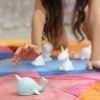 A picture of a little girl playing with a pale blue baby narwhal LED night Light
