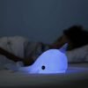 A glowing narwhal night light which is pale blue.