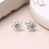 A pair of white flower stud earrings. The petals are made from white enamel and the centre of the flower has a little crystal.