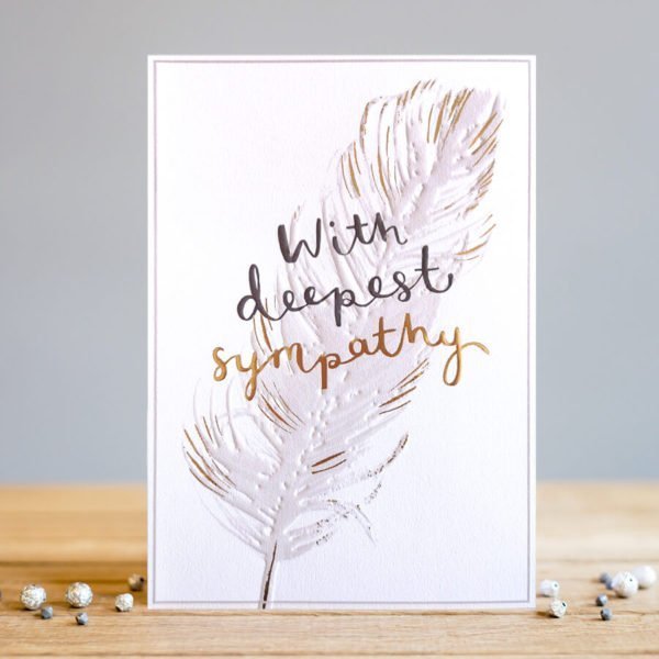 A rectangular card whit and image of a feather which has been embossed and printed with a subtle gold foil effect. The words deepest sympathy are also embossed and printed in black and gold foil.