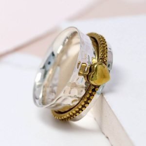 silver spinning ring with a moving brass band with a little heart