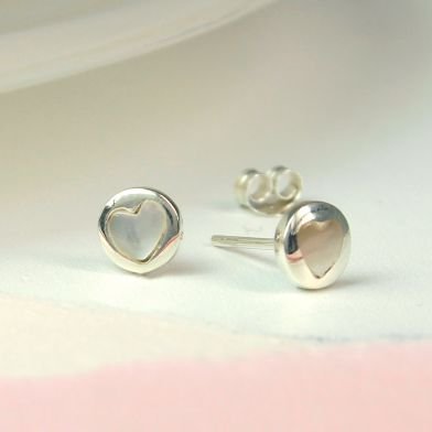 A pair of silver and pearl heart studs. These sterling silver earrings have a pearl heart inset.