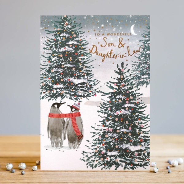 A wintery night time card for a Son and Daughter in Lawwith snow covered Christmas tree with a couple of penguins that are tied together with a scarf.