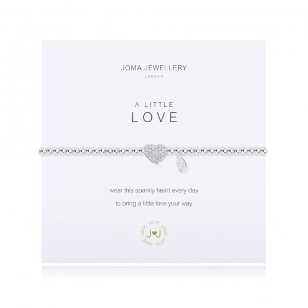 A silver plated bracelet from Joma Jewellery with a sparkly heart charm on it which is wrapped around a card with the wording A Little Love printed on it.