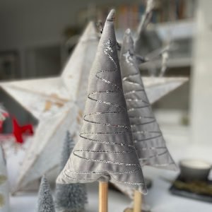 A lovely silver plush tree on a wooden trunk and base. There is a sequin pattern zigzagging down the tree giving added silver sparkle.