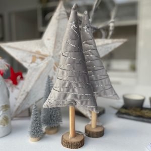 A lovely silver plush tree on a wooden trunk and base. There is a sequin pattern zigzagging down the tree giving added silver sparkle.