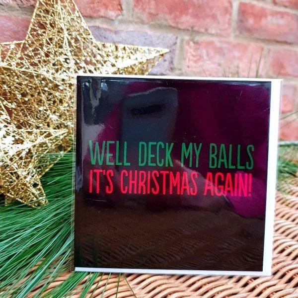 A funny Christmas card. A black card with red and green text that reads Well Deck My Balls it's Christmas again.