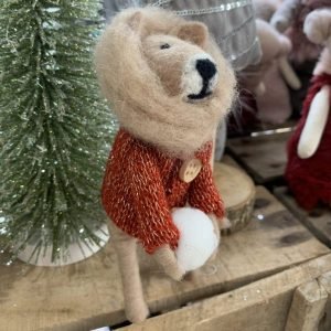 A lion Christmas decoration with a lovely mane, a red jumper and holding a snowball.