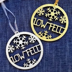 Low Fell Christmas decorations. A laser cut wooden circle with snow flakes and low fell inside the circle in either silver or gold