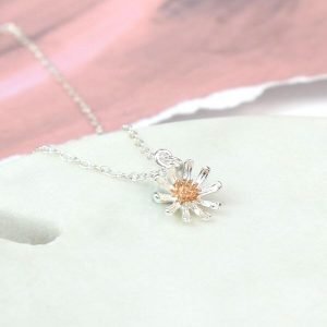 A silver daisy with a rose gold centre on a fine silver chain necklace