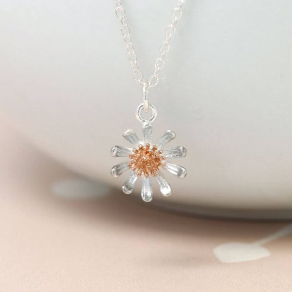 A silver daisy with a rose gold centre on a fine silver chain necklace