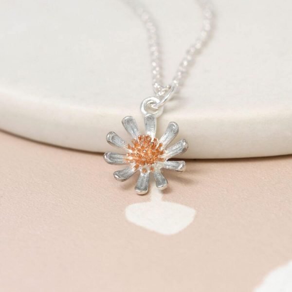 A silver daisy with a rose gold centre on a fine silver chain necklace