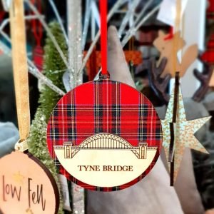 A round hanging decoration with the Tyne Bridge cut out in wood