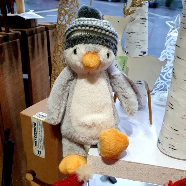 A cuddly grey blue penguin in a bobble hat from Jellycat
