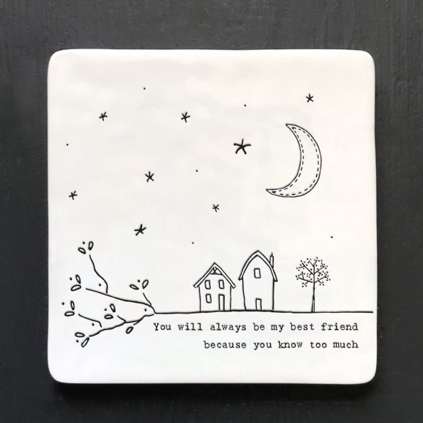 A white square ceramic coaster with an image of houses and the moon and stars and with the wording 'You will always be my friend you know too much'.