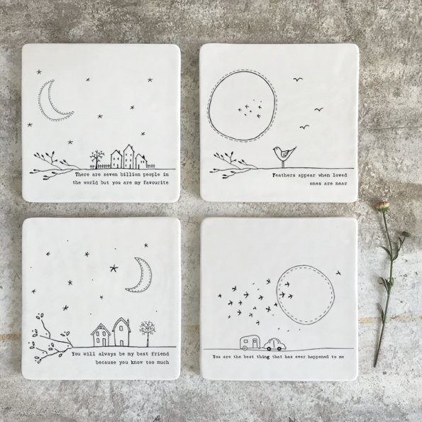 A white square ceramic coaster with an image of houses and the moon and stars and with the wording 'You will always be my friend you know too much'.