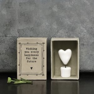 A little ceramic keepsake of a heart on a stick in a pot, with a cardboard matchbox with the wording 'Wishing you every happiness for the future.'