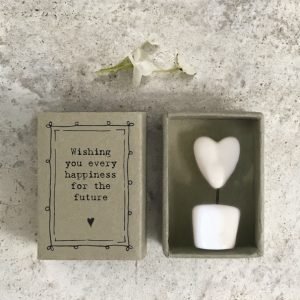 A little ceramic keepsake of a heart on a stick in a pot, with a cardboard matchbox with the wording 'Wishing you every happiness for the future.'