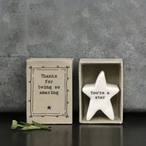 A lovely porcelain star with You're a star written on it. The star is stored in a cardboard matchbox with the words 'Thanks for being so Amazing' printed on it.