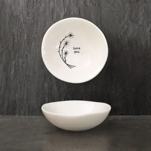 A white ceramic dish from design company East of India with a flower design and the words 'Love You' imprinted in the middle of it.