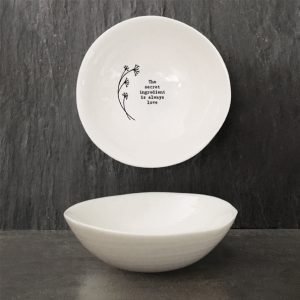 A sweet white ceramic dish from British design company East of India, with a flower design and the wording 'The Secret Ingredient is Always Love' imprinted on it.
