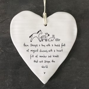 A white ceramic wobbly heart from British design company East of India. The words Here sleeps a boy with a head full magical dreams, a heart full of wonder and hands that will shape the world' imprinted on it.