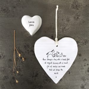 A white ceramic wobbly heart from British design company East of India. The words Here sleeps a boy with a head full magical dreams, a heart full of wonder and hands that will shape the world' imprinted on it.
