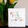A card covered with gold spots and colourful lettering that reads Good Luck in your new job