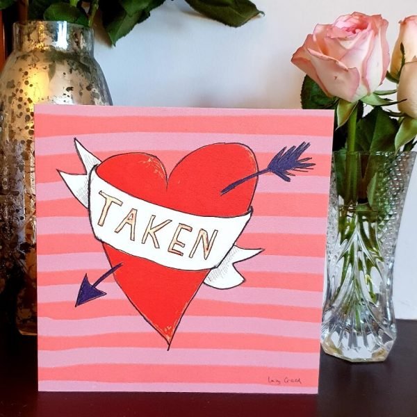 A Valentine'sDay card with a big hand drawn heart with an arrow through it and a scroll with Taken on it.