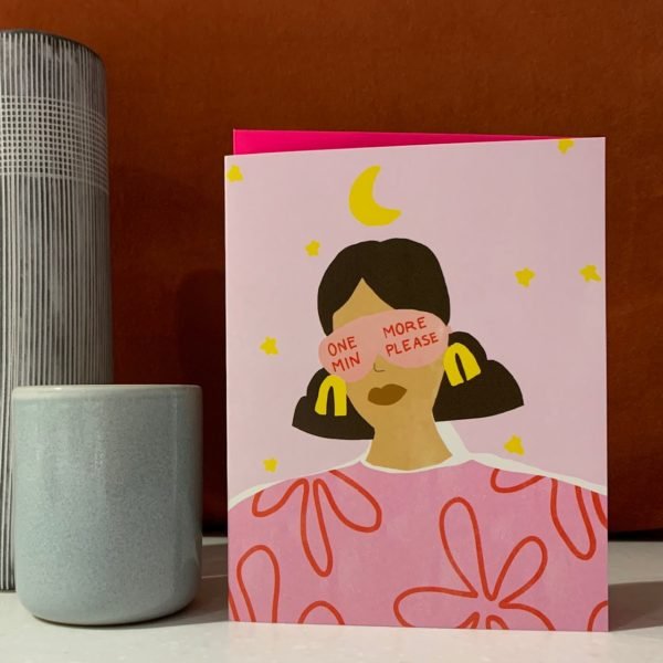 A card with an image of woman wearing a face mask that has the words One More Min Please printed on it. The card is left blank
