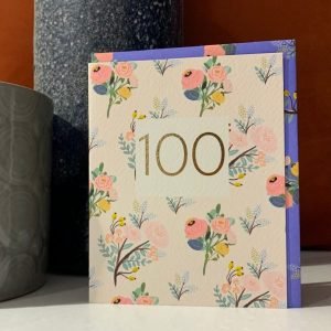 A floral card with an embossed gold square in the centre of the card and the number 100 embossed inside the square