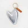 An extra large silver vegan leather heart shaped keyring, with a gold ring and leather tag.