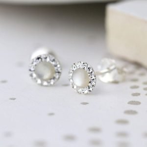 A pair of sterling silver pearl and crystal studs. The studs have a pearl centre which is surrounded by tiny crystals around the edges.