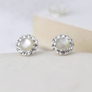 A pair of sterling silver pearl and crystal studs. The studs have a pearl centre which is surrounded by tiny crystals around the edges.