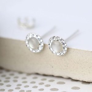 A pair of sterling silver pearl and crystal studs. The studs have a pearl centre which is surrounded by tiny crystals around the edges.