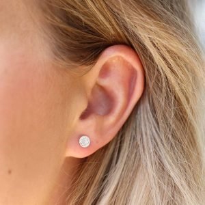 A pair of sterling silver pearl and crystal studs. The studs have a pearl centre which is surrounded by tiny crystals around the edges.