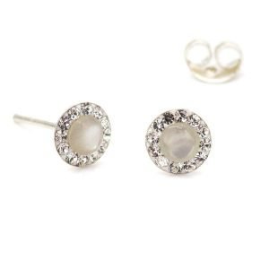 A pair of silver stud earrings with a mother of pearl centre and surrounded by tiny crystals around the edges.