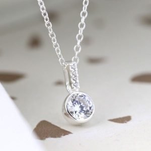 A silver drop pendant with a crystal inset and crystal stem, on a silver chain.