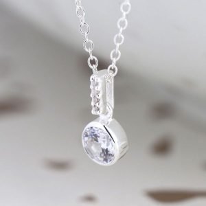 A silver drop pendant with a crystal inset and crystal stem, on a silver chain.